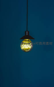 深蓝背景下复古爱迪生灯泡悬挂，灯丝亮起‘Love’字样，浪漫工业风静物摄影