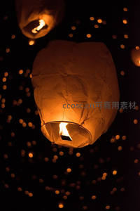 夜空中飘浮的孔明灯，暖光点缀深邃黑暗