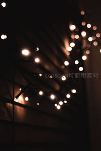 暗调背景下悬挂串灯特写，光斑散景如星尘闪烁