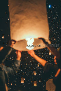 双手托举孔明灯升空，夜空繁星点点如萤火漫天飞舞