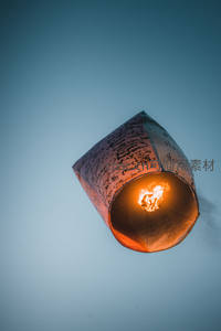 手写祝福的孔明灯升向淡蓝天空，火焰跃动承载心愿