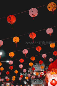 彩灯高悬夜市上空，红白灯笼串串交织，映衬古庙飞檐轮廓