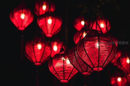 夜色中悬挂的红色传统纸灯笼，温暖光晕映照树影