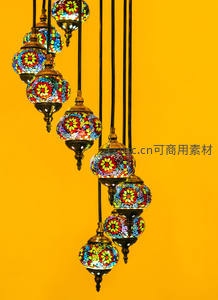 彩色马赛克玻璃吊灯群垂挂于明黄背景前，绽放异域风情与艺术光韵