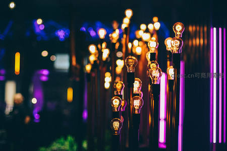 霓虹夜景中林立灯泡装置，暖光与紫蓝光交织，营造赛博朋克氛围