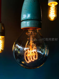 复古爱迪生灯泡特写，暖光螺旋灯丝与青瓷灯头交相辉映
