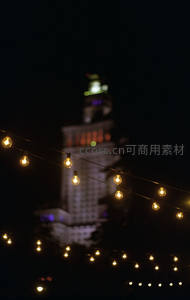夜幕下串灯闪烁，远处模糊高楼轮廓营造梦幻都市氛围