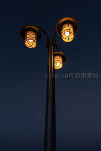 夜幕下三头路灯仰拍，复古铁艺灯笼散发温暖光芒