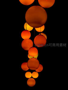 悬浮球形灯串艺术装置，橙红渐变光球在纯黑背景中层叠排列