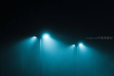 雾夜中四盏蓝光路灯穿透薄雾的静谧街景