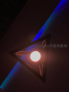 三角形灯罩内暖光球体与蓝紫光束交织的抽象光影艺术