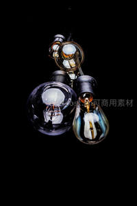 黑底微距下三款复古爱迪生灯泡特写：玻璃质感与钨丝细节清晰可见