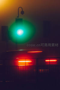 雾夜绿灯与车流光轨交织的城市街景特写