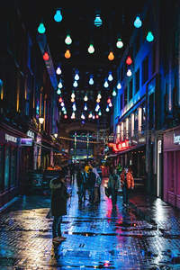 雨夜霓虹街巷，彩灯悬空映照湿漉石板路与行人剪影