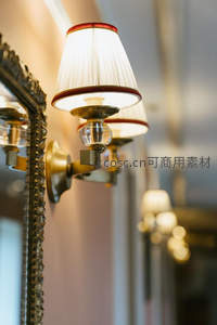 古典壁灯与雕花镜框并置，褶皱灯罩透出柔和光线，映衬欧式优雅格调