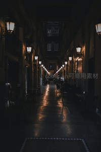 幽深欧式小巷灯火通明，石板路反射暖光延伸至远方