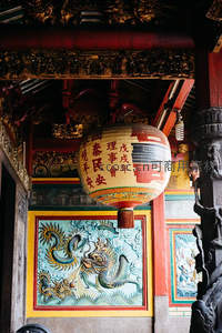 传统庙宇悬挂彩绘灯笼与龙纹浮雕壁画特写