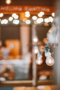 咖啡馆外悬挂复古爱迪生灯泡，背景虚化暖光斑驳，营造温馨惬意氛围
