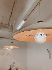 工业风吊灯特写，暖光灯泡与水泥灯罩营造温馨复古氛围