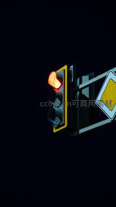 夜幕中黄灯亮起的交通信号灯特写，警示意味强烈构图简洁