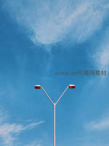 蓝天白云下Y型路灯剪影，简约现代城市照明设施