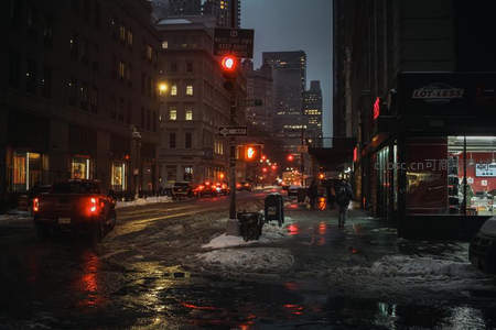 雪夜城市街景：红灯闪烁，车流穿行湿滑路面