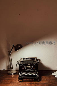 Mercedes牌打字机静置于书桌，台灯斜照营造沉思写作氛围