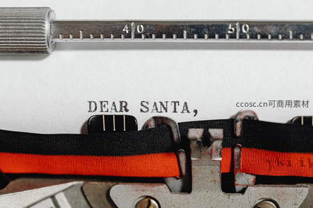 打字机纸上打出'DEAR SANTA,'字样，红黑墨带映衬节日温情