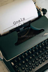 打字机纸张上印着'Goals'字样，象征目标设定与计划启程