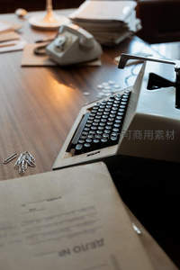 斜角构图下的老式打字机与散落回形针办公桌面