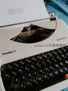白色Olympia Traveller C便携打字机特写，纸页印有西班牙语诗句