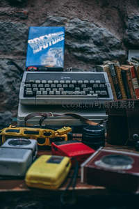 老式皇家打字机与复古书籍静物组合，石墙背景怀旧氛围