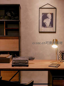 简约工业风书桌陈设：打字机、铜灯与古典雕塑画作和谐共存